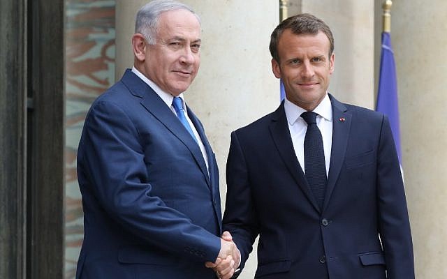 French President Emmanuel Macron shakes hands with then-prime minister Benjamin Netanyahu (L) at the Elysee Palace in Paris on June 5, 2018. (AFP/Ludovic Marin/File)