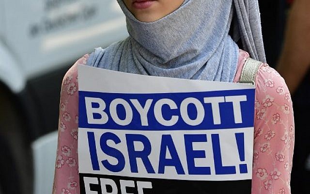 Illustrative: A protester holds a sign reading 'Boycott Israel, Free Palestine' during a Quds-day demonstration in Berlin, on June 9, 2018. (AFP PHOTO / Tobias SCHWARZ)