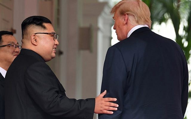 North Korea's leader Kim Jong Un (C) meets with US President Donald Trump (R) at the start of the US-North Korea summit at the Capella Hotel on Sentosa island in Singapore on June 12, 2018. (AFP Photo/Saul Loeb)