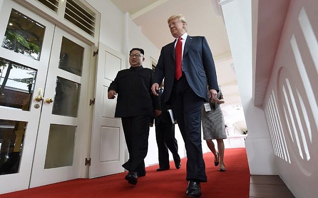 North Korea's leader Kim Jong Un (L) walks with US President Donald Trump (R) at the start of their historic US-North Korea summit, at the Capella Hotel on Sentosa island in Singapore, on June 12, 2018. (AFP Photo/Saul Loeb)