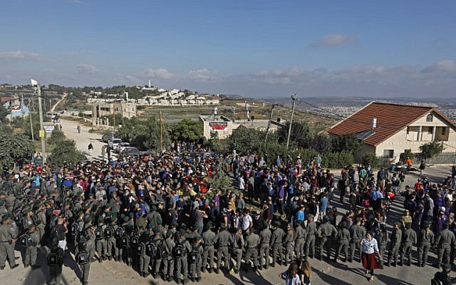 Protesters scuffle with police at the Netiv Ha’Avot outpost, in the West Bank on June 12, 2018. (Menahem KAHANA/AFP)