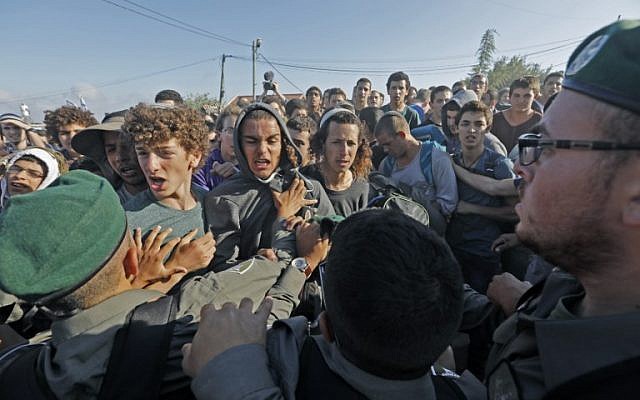 Settlers scuffle with security forces at Netiv Ha'avot settlement, near Bethlehem, in the West Bank on June 12, 2018. (AFP PHOTO / Menahem KAHANA)
