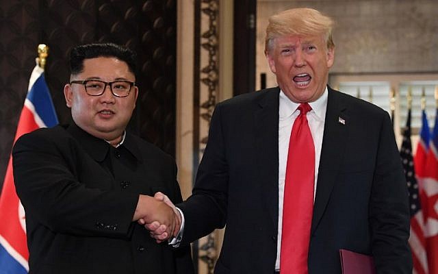 US President Donald Trump (R) and North Korea's leader Kim Jong Un shake hands following a signing ceremony during their historic US-North Korea summit, at the Capella Hotel on Sentosa island in Singapore on June 12, 2018. (AFP PHOTO / SAUL LOEB)