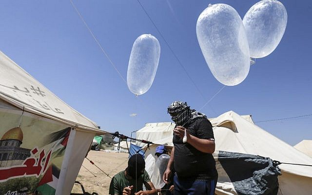 Palestinian protesters prepare kites loaded with flammable material to be flown towards Israel, at the Israel-Gaza border in al-Bureij, central Gaza Strip on June 14, 2018. (AFP PHOTO / MAHMUD HAMS)