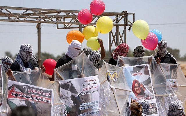 Palestinian protesters holds ballons and kites before loading them with flammable material to be flown towards Israel, at the Israel-Gaza border in al-Bureij, central Gaza Strip on June 14, 2018. ( AFP PHOTO / MAHMUD HAMS)