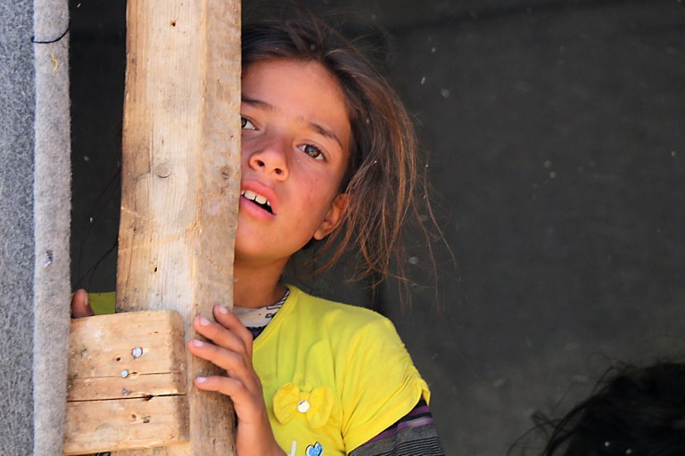 A displaced Syrian girl from Daraa stands in a makeshift camp in Quneitra, southwestern Syria, near the border with Israel, on June 22, 2018. (AFP PHOTO / Ahmad al-Msalam)