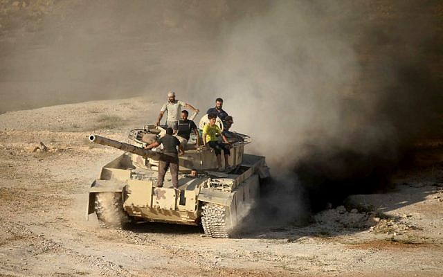 Syrian rebel fighters ride a tank in Daraa, southwestern Syria, on June 23, 2018. (AFP / Mohamad ABAZEED)