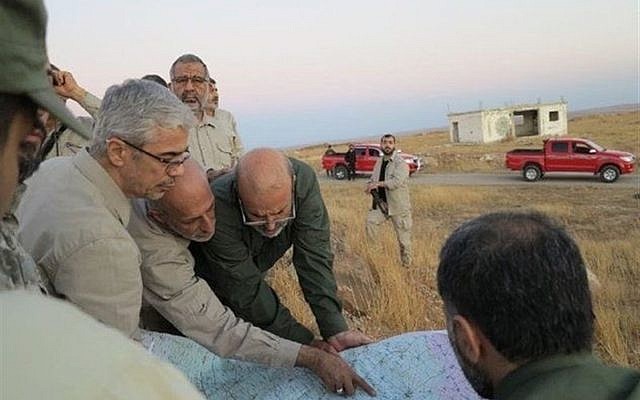 This file photo provided on October 20, 2017 by the government-controlled Syrian Central Military Media shows Iran's army chief of staff Maj. Gen. Mohammad Bagheri, left, looking at a map with senior officers from the Iranian military as they visit a front line position in the northern province of Aleppo, Syria. (Syrian Central Military Media, via AP)