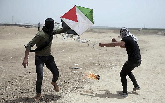 Palestinian protesters fly a kite with a burning rag dangling from its tail to during a protest at the Gaza Strip’s border with Israel, Friday, April 20, 2018. Activists use kites with burning rags dangling from their tails to set ablaze drying wheat fields on the Israeli side. (AP Photo/ Khalil Hamra)