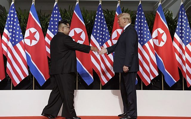 US President Donald Trump (right) reaches to shake hands with North Korea leader Kim Jong Un at the Capella resort on Sentosa Island, June 12, 2018, in Singapore. (AP Photo/Evan Vucci)