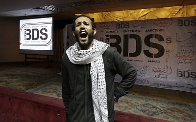 An Egyptian man shouts anti-Israeli slogans in front of banners with the Boycott, Divestment and Sanctions (BDS) logo during the launch of an Egyptian campaign that urges boycott, divestment and sanctions against Israel and Israeli-made goods, at the Egyptian Journalists’ Syndicate in Cairo, April 20, 2015 (AP Photo/Amr Nabil, File)