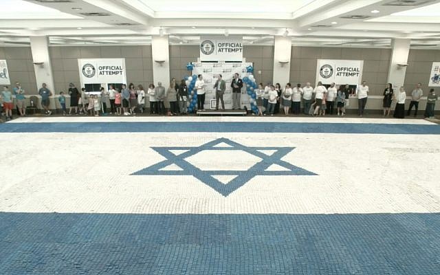 Screen capture from video of a world-record breaking Israeli flag made out of cookies on the floor of the Heritage Hall in Atlanta’s Congregation Beth Jacob, June 3, 2018. (YouTube)