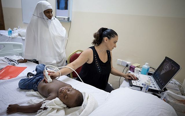 An Echo Technician from Wolfson Medical Center in Israel, examines the heart of a child at the Save a Child's Heart clinic in Zanzibar, March 5, 2018. (Nati Shohat/FLASH9)