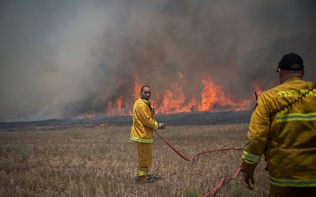 File: Israeli firefighters battle a blaze in a field in southern Israel caused by kites flown by Palestinians from the Gaza Strip on June 5, 2018. (Yonatan Sindel/Flash90)