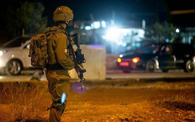 Illustrative. Israeli soldiers stand near the scene of a suspected car-ramming attack at the entrance to the village of Husan, in the West Bank, on June 23, 2018. (Flash90)