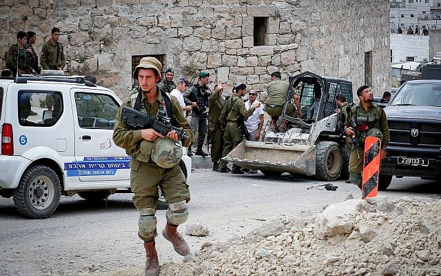 Israeli soldiers at the scene of an attempted ramming attack in the West Bank city of Hebron on June 2, 2018. (Wisam Hashlamoun/Flash90)
