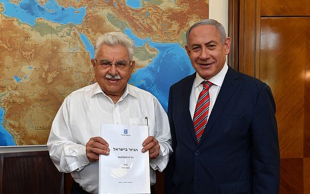 Prime Minister Benjamin Netanyahu (R) receives a report by Moshe Nissim (L) on a proposed overhaul of the conversion to Judaism system in Israel on June 3, 2018. (Kobi Gideon/GPO)