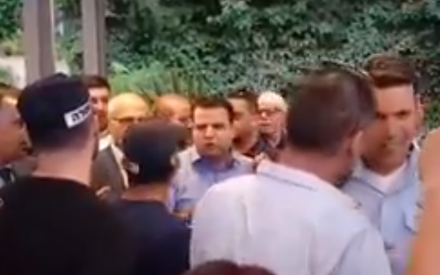 Joint (Arab) List MK Ayman Odeh (C) argues with police during an event in East Jerusalem hosted by the Popular Front for the Liberation of Palestine and Democratic Front for the Liberation of Palestine terror groups on June 18, 2018. (Screen capture: Twitter)