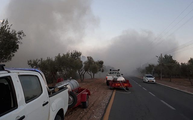 Local security officers work to put out a fire, sparked by incendiary balloons from the Gaza Strip, in the Hevel Shalom area of southern Israel on June 26, 2018. (Eshkol Security)