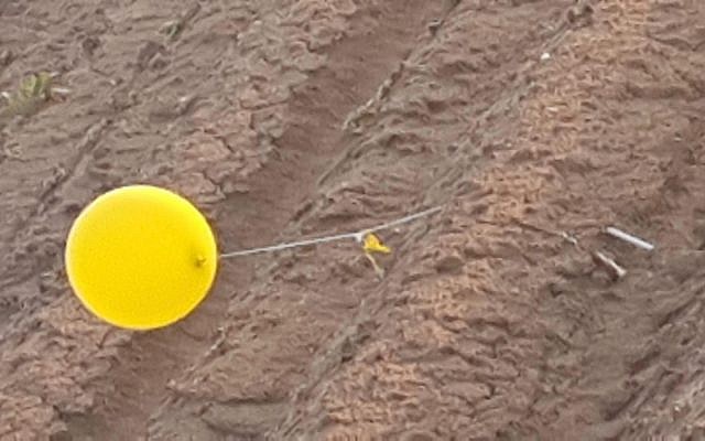 Illustrative: A balloon carrying a suspected explosive device from the Gaza Strip touches down in southern Israel on February 20, 2019. (Eshkol Security)