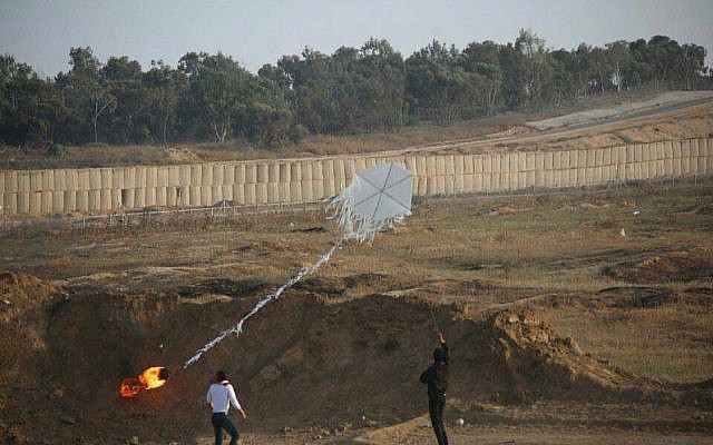 Two Palestinians help fly a 'fire kite' from the Gaza Strip into Israeli territory during mass demonstrations along the security fence on June 8, 2018. (Israel Defense Forces)