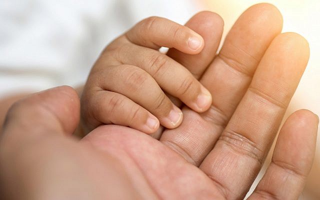 Illustrative image of a baby holding hands (boonchai wedmakawand; iStock by Getty Images)