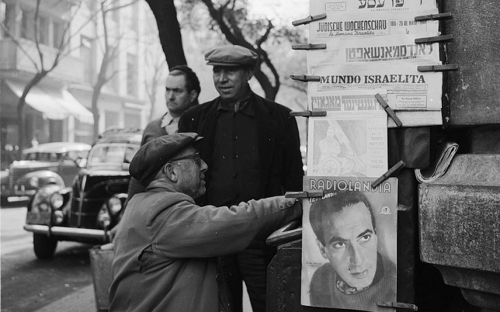 A man buying Jewish newspapers from a stall in Buenos Aires, circa 1956. (Evans/Three Lions/Getty Images)