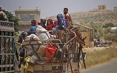 Syrians displaced by government forces' bombardment in the southern Daraa province countryside drive near the town of Shayyah, south of the city of Daraa, towards the demilitarized zone separating the Israeli and Syrian Golan heights on June 29, 2018. (AFP Photo/Mohamad Abazeed)