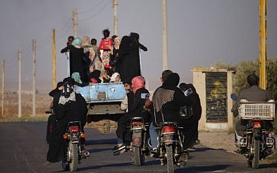 Syrians ride a vehicle carrying their personal belongings, as they return to their homes in towns and villages situated on the eastern outskirts of Daraa, on July 7, 2018. (AFP Photo/ Mohamad Abazeed)