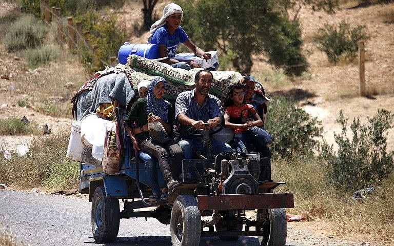 Syrians ride a vehicle carrying their personal belongings as they return to their homes in towns and villages situated on the eastern outskirts of Daraa on July 7, 2018. (AFP Photo/Mohamad Abazeed)