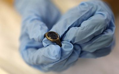 Curator Morag Wilhelm holds a signet ring that had been given by Sigmund Freud to close students, at the Israel Museum in Jerusalem on July 12, 2018. (AFP PHOTO / MENAHEM KAHANA)