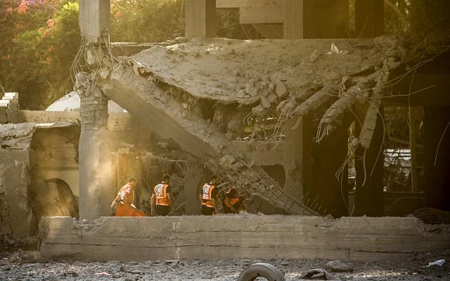 Members of the Palestinian civil defense search for survivors in a building that was hit by Israeli airstrikes (AFP/MAHMUD HAMS)