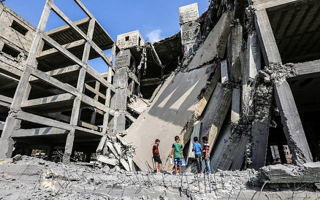 Palestinian boys walk through the wreckage of a building that was damaged by Israeli air strikes in Gaza City on July 15, 2018. (AFP / MAHMUD HAMS)