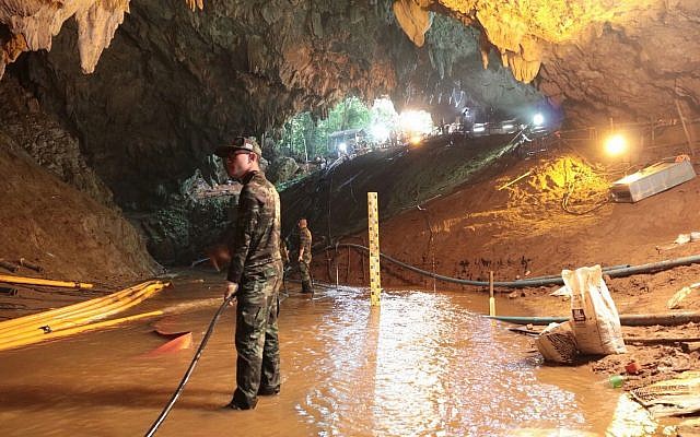 In this undated photo released by Royal Thai Navy on July 7, 2018, Thai rescue teams arrange water pumping system at the entrance to a flooded cave complex where 12 boys and their soccer coach have been trapped since June 23, in Mae Sai, Chiang Rai province, northern Thailand. (Royal Thai Navy via AP)