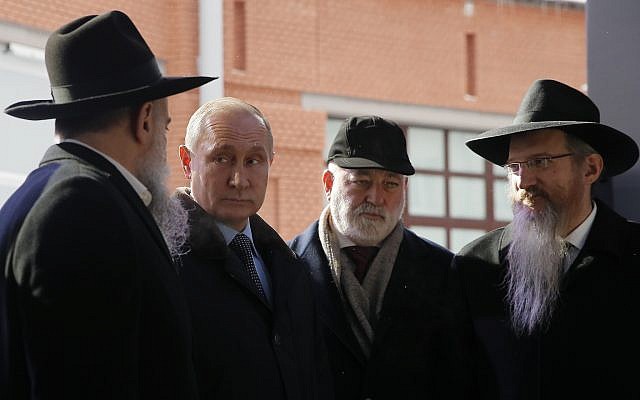 Russian President Vladimir Putin accompanied by Head of the Russian Federation of Jewish Communities and the museum's director Alexander Boroda, left, businessmen Viktor Vekselberg, second from right, and Russia's chief rabbi, Berel Lazar, right, stands next the stone of the memorial to members of the resistance at Nazis concentration camps during WW II, at the Jewish Museum and Center for Tolerance in Moscow, Russia, Monday, January 29, 2018. (Maxim Shemetov/Pool Photo via AP)