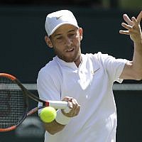 Dudi Sela of Israel returns the ball to Spaniard Rafael Nadal during their men's singles match, on the second day of the Wimbledon Tennis Championships in London, July 3, 2018. (AP Photo/Ben Curtis)