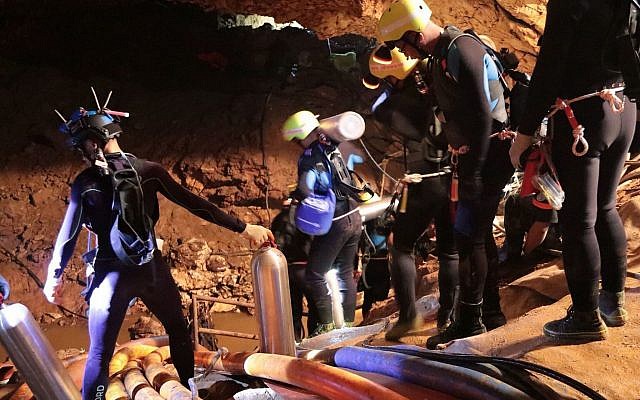 In this undated photo released by Royal Thai Navy on Saturday, July 7, 2018, Thai rescue team members walk inside a cave where 12 boys and their soccer coach have been trapped since June 23, in Mae Sai, Chiang Rai province, northern Thailand (Royal Thai Navy via AP)