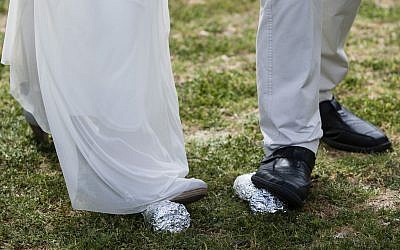 The legs of bride Lin Dror (L) and groom Alon Marcus (R) are seen as they break two glasses concluding their Reform Jewish wedding ceremony held in front of the Knesset, in Jerusalem, on March 18, 2013, in protest of the Orthodox Rabbinate's monopoly on marriage licensing and the lack of civil marriages in Israel. (Flash90)