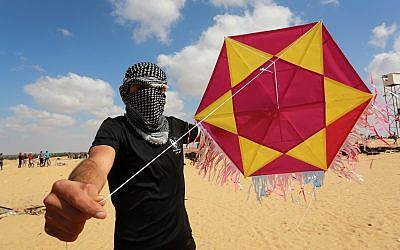 A Palestinian protester displays a kite loaded with an incendiary device before launching it towards Israel, east of Rafah in the southern Gaza Strip, on June 29, 2018 (Abed Rahim Khatib/Flash90)