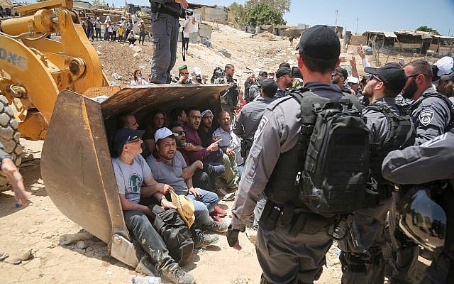 Israeli policemen scuffle with Palestinian demonstrators in the Bedouin village of Khan al-Ahmar, east of Jerusalem, on July 4, 2018. (FLASH90)