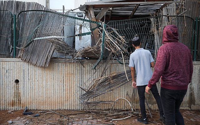 People at the scene where a courtyard of a house was hit by a Gaza rocket in the southern Israeli city of Sderot, on July 14, 2018. (Hadas Parush/Flash90)
