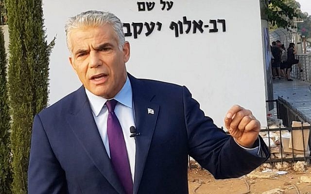 Yesh Atid leader MK Yair Lapid speaks to reporters outside the IDF's main recruitment base, the Bakum, in Tel Hashomer on August 13, 2018. (Courtesy)