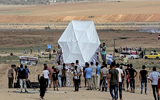 Palestinians prepare to fly a kite near the Gaza border with Israel, east of Jabalia, on August 3, 2018. (AFP/ MAHMUD HAMS)