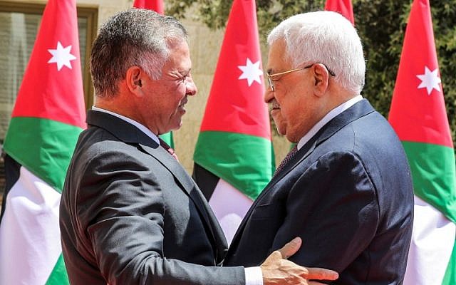 Illustrative: Palestinian Authority President Mahmoud Abbas (R) embraces King Abdullah II of Jordan as he arrives to meet with him at the Royal Palace in the capital Amman on August 8, 2018. (AFP/Pool/Khalil Mazraawi)