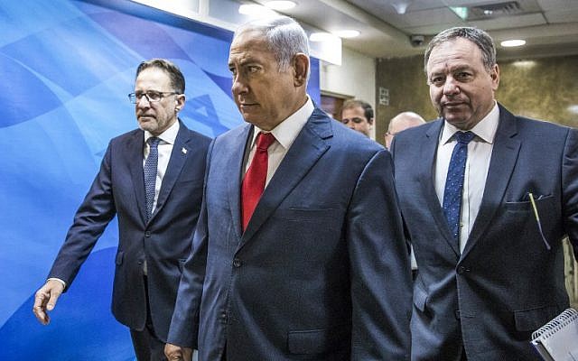 Prime Minister Benjamin Netanyahu, center, arrives ahead of the weekly cabinet meeting at his office in Jerusalem, August 12, 2018. (Jim Hollander/AFP)