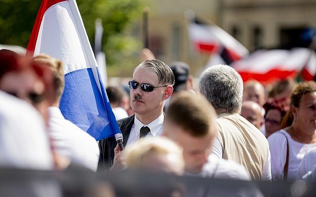 An Adolf Hitler lookalike attends a demonstration commemorating the 31st anniversary of the death of Hitler's deputy Rudolf Hess, in Berlin Saturday, Aug 18, 2018. Hess died 1987 in a prison in Berlin. (Christoph Soeder/dpa via AP)