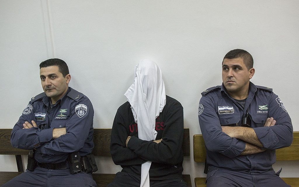 Ben Deri, center, a Border Police officer accused of shooting to death a Palestinian man during clashes in Betunia in the West Bank, seen during a hearing at the District Court in Jerusalem on December 30, 2014. (Yonatan Sindel/Flash90)