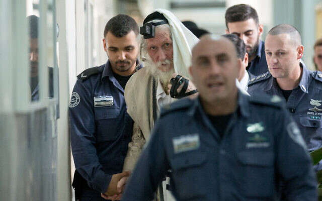 Eliezer Berland covers himself with his talit (prayer shawl) at the Magistrate Court in Jerusalem, as he is put on trial for sexual assault charges, on November 17, 2016. (Yonatan Sindel/ Flash90)