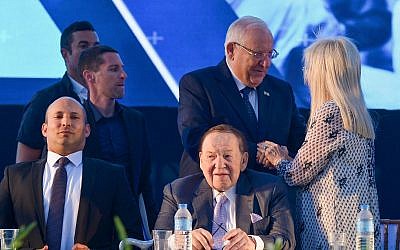 American businessman and investor Sheldon Adelson (sitting R), his wife Miriam with President Reuven Rivlin (standing middle) and Education Minister Naftali Bennett (L) at the ceremony for a medical school at Ariel University in the West Bank, on August 19, 2018. (Ben Dori/Flash90)