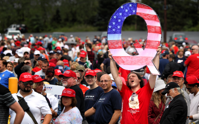 David Reinert holds up a large “Q” sign, representing QAnon, a conspiracy theory group, while waiting in line to see President Donald Trump at a rally in Wilkes-Barre, Pa., Aug. 2, 2018. (Rick Loomis/Getty Images via JTA)